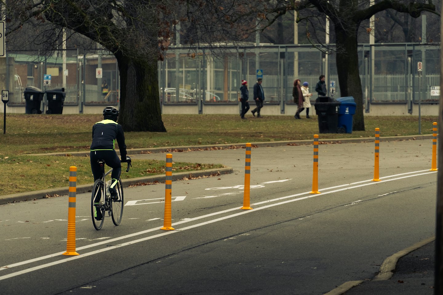 Radfahrer in neongrüner Jacke fährt auf einem Radweg.
