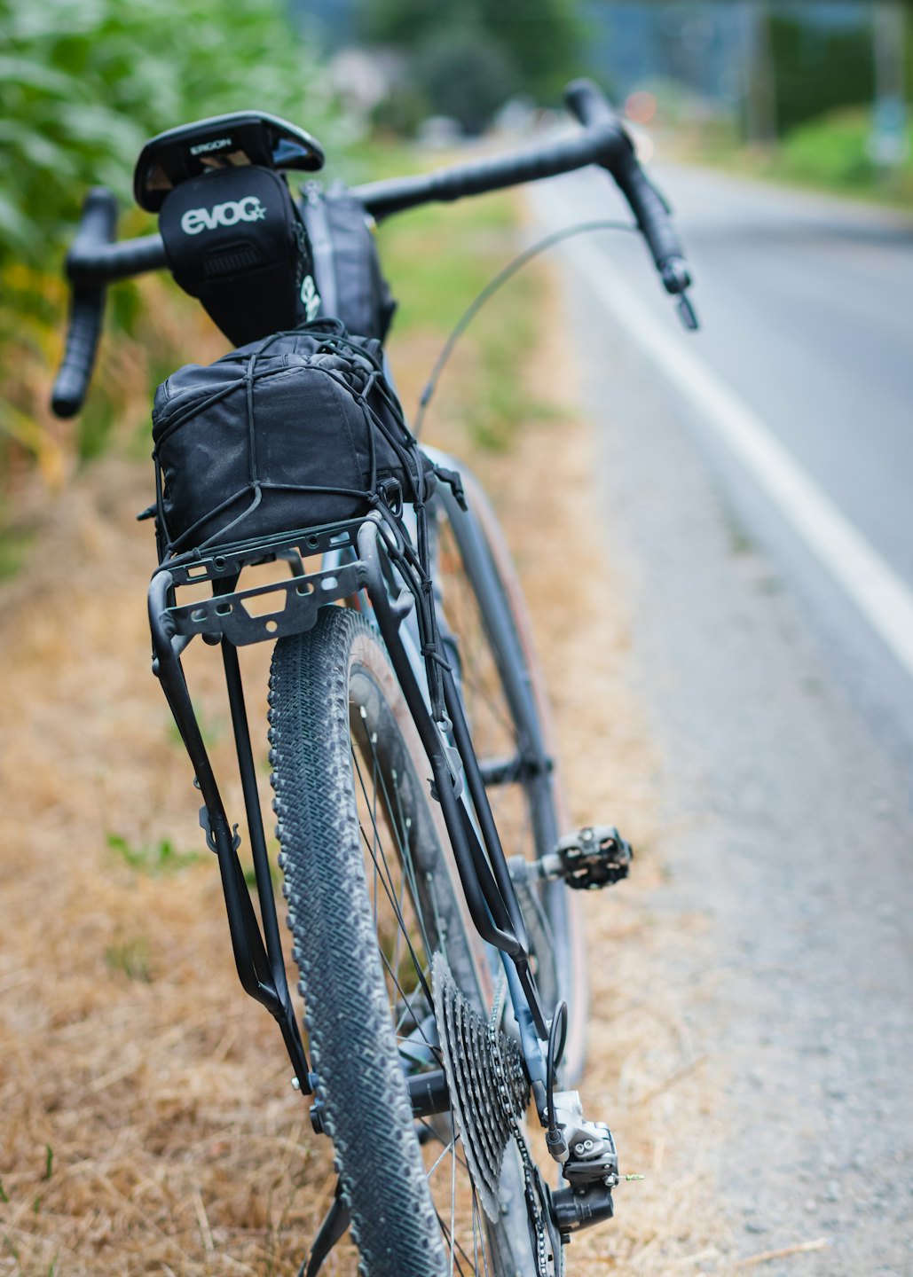 Gravelbike mit Bikepacking-Taschen auf einer Asphaltstraße geparkt.